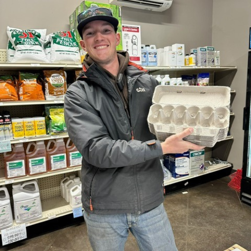 Roger's staff holding empty egg containers inside of the store