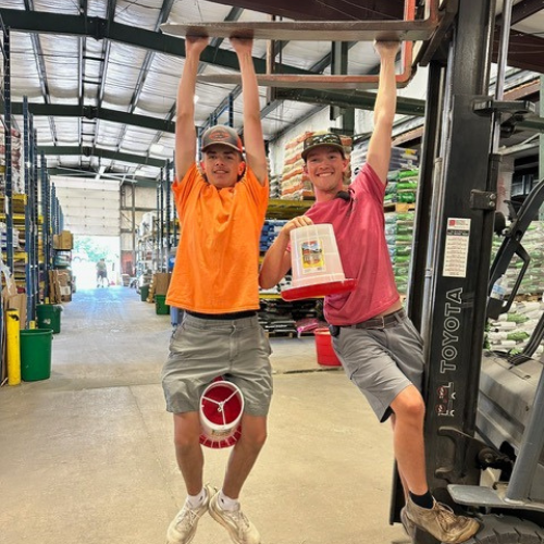 Roger's staff being fun hanging off of the end of a forklift with supplies